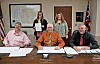 Local officials at a meeting with documents on the table.