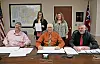 Local officials at a meeting with documents on the table.