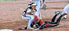Softball player slides into base while catcher applies a tag during an infield play.
