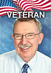 Portrait of a smiling older man beneath a U.S. flag graphic and the word veteran.