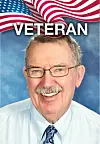 Portrait of a smiling older man beneath a U.S. flag graphic and the word veteran.