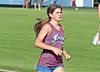 Athlete running on a green grass field wearing a blue and red patterned uniform.