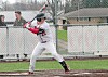 Baseball player in a batting stance near home plate on an outdoor field.