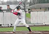 Baseball player in a batting stance near home plate on an outdoor field.