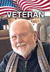 Smiling older man in a scarf with an American flag graphic and the word “VETERAN” above him.