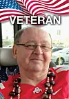 Portrait of an older man in a red shirt and beaded necklace with a U.S. flag and the word Veteran above him.