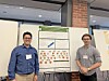 Two men standing on either side of a poster board at an indoor presentation.