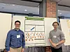 Two men standing on either side of a poster board at an indoor presentation.