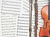 Open binder with sheet music next to a violin.