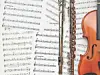 Open binder with sheet music next to a violin.