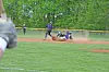 Baseball players in action on an infield with one player sliding near the base.