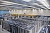 Rows of server racks inside a large, brightly lit data center.