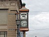 Clock sign mounted on a brick building with “Minerva Ohio” and “Est. 1833” visible.