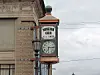 Clock sign mounted on a brick building with “Minerva Ohio” and “Est. 1833” visible.