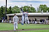 Two baseball players jump and celebrate on a baseball field near the dugout.