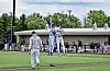 Two baseball players jump and celebrate on a baseball field near the dugout.
