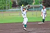 Softball player in white uniform celebrates on the infield with a raised glove.