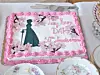 Pink decorated cake with butterfly details and anniversary message on a set dining table.