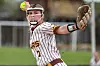 Softball pitcher in a striped uniform throwing a pitch with glove extended.