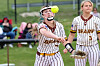 Softball player in a Bears uniform reaches toward a ball while another player stands nearby.
