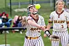 Softball player in a Bears uniform reaches toward a ball while another player stands nearby.