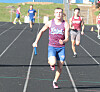 Runners compete on an outdoor track, with a baton carrier leading in the foreground.
