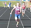 Runners compete on an outdoor track, with a baton carrier leading in the foreground.
