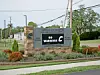 A Carrolton Elementary School sign beside a sidewalk, street, and landscaped planting bed.