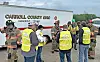 Several workers in reflective vests and helmets stand near a Carroll County, Ohio hazardous utility trailer outdoors.