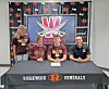 Three student-athletes and one adult pose behind a Ridgewood Generals signing table with banners in the background.