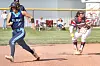 Two softball players run across the infield during a game.