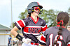Two softball players in gray and red uniforms stand on a softball field.
