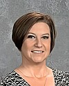 Portrait of a woman with short brown hair against a gray background.