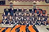 A girls basketball team poses for a group photo in a gym with banners and a tiger logo on the floor.