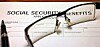 Social Security benefits application form with eyeglasses and a pen on a desk.