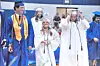 Graduates in caps and gowns walk together at a commencement ceremony.