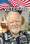 Smiling older man indoors beneath an American flag graphic and the word VETERAN.