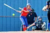 Softball batter in red swings at a pitch while catcher and umpire crouch behind home plate.