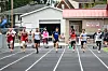 Several runners sprint on a track toward the finish line.