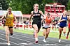 Four runners compete in a sprint race on an outdoor track.