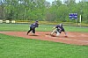 Two baseball players slide headfirst into a base on a dirt infield.