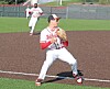 Baseball player in a ready stance on the infield with another player in the background.