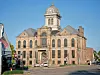 Historic stone courthouse building with a clock tower on a sunny day.