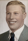 Smiling young man in a suit jacket, white shirt, and dark tie posed against a plain background.