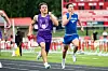 Two runners sprint on a track near the finish line during a stadium race.