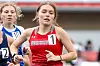 Two female runners compete in a track race, with one in a red Norway jersey in front.