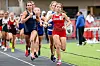 Several female runners compete on a track, with one runner in red leading the group.