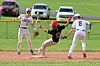 Base runner slides into a base while two fielders watch during a baseball game.