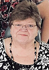 Close-up of a woman wearing glasses and a black-and-white patterned top.