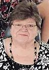 Close-up of a woman wearing glasses and a black-and-white patterned top.